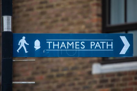 Close-up of a sign pointing visitors to the direction of the Thames Path in London, UK.