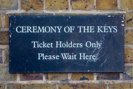 Ein Schild, das Besuchern zeigt, wo sie bei der Schlüsselübergabe am Tower of London in London Schlange stehen müssen.