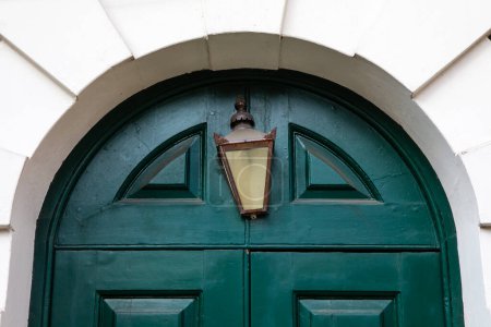 Nahaufnahme einer Vintage-Lampe über dem Eingang der historischen St. Botolph Without Aldgate Kirche in der City of London, Großbritannien.