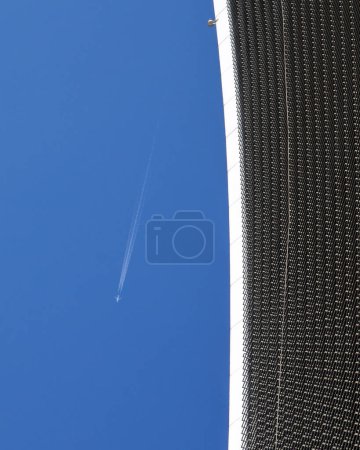 An Aeroplane flying high above 20 Fenchurch Street, also known as the Walkie Talkie Building in the City of London, UK.