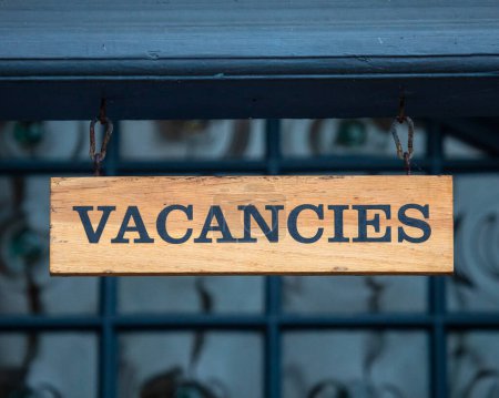 Close-up of a Vacancies sign on the exterior of a guesthouse in the UK.