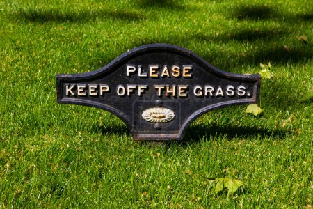 Close-up of a Please Keep Off The Grass sign.
