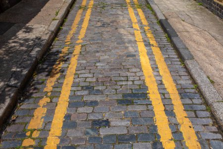 Doppelte Gelbe Linien auf einer schmalen Straße in London, Großbritannien.