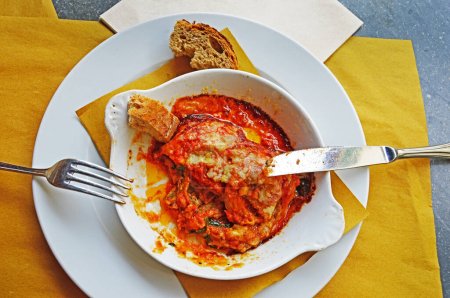 Parmigiana is an Italian dish of fried, sliced eggplant, with cheese and tomato sauce and baked. It comes from the southern regions of Italy: Calabria, Campania, Apulia and Sicily. Selective focus