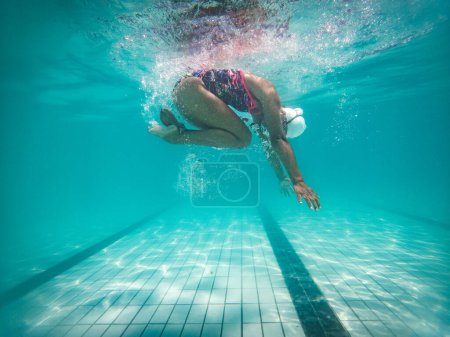 Foto de Una talentosa nadadora se sumerge en un grupo de torneos de tamaño completo para entrenar o competir. - Imagen libre de derechos
