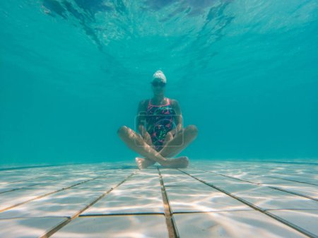 Téléchargez les photos : Une nageuse talentueuse plonge dans une piscine de tournoi pleine grandeur pour s'entraîner ou concourir. - en image libre de droit