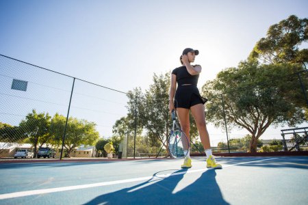 Téléchargez les photos : Une jeune joueuse de tennis en action sur un tout nouveau court de tennis. - en image libre de droit