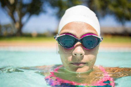 Téléchargez les photos : Nageuse talentueuse en pleine action dans une piscine de la taille d'un tournoi par une journée chaude et ensoleillée. - en image libre de droit