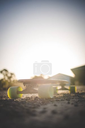 Téléchargez les photos : Skateboard capturé dans la lumière dorée du soleil de fin d'après-midi. - en image libre de droit