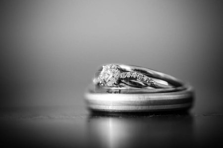 Photo for This stunning close-up image of wedding rings captures the beauty and symbolism of the cherished wedding tradition. The photograph features the bride and groom's wedding rings delicately placed on a neutral surface, highlighting the intricate details - Royalty Free Image