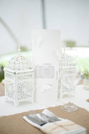Photo for This captivating image showcases the elegant decor and stunning floral arrangements of a real wedding. The photograph features a beautifully decorated table in a charming wedding venue, adorned with delicate flowers, candles, and other decorative ele - Royalty Free Image