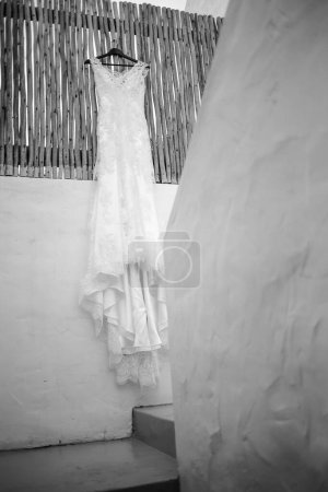 Téléchargez les photos : Cette image captivante présente une robe de mariée avec des détails complexes photographiés de manière créative et unique. La photographie présente une superbe robe de mariée blanche avec des détails complexes en dentelle et des perles délicates. La robe est photographiée - en image libre de droit