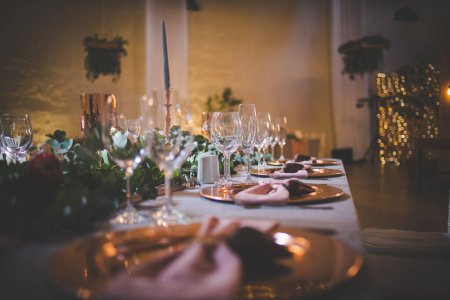 Dieses fesselnde Bild zeigt das elegante Dekor und die atemberaubenden Blumenarrangements einer echten Hochzeit. Das Foto zeigt einen wunderschön dekorierten Tisch in einer charmanten Hochzeitslocation, geschmückt mit zarten Blumen, Kerzen und anderen dekorativen Elementen.