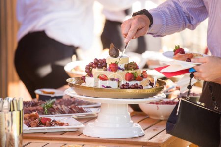 This stunning image showcases a creative and beautifully composed photograph of food, canapes, and desserts served at weddings. The photograph is a feast for the eyes, featuring mouth-watering dishes with vibrant colors and textures. The image is per