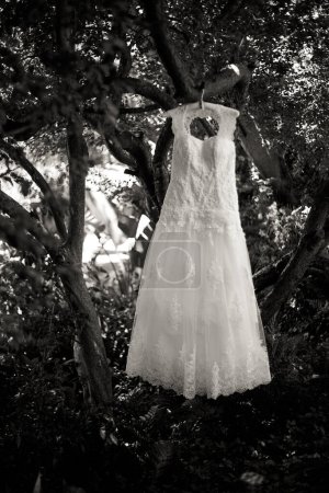 Téléchargez les photos : Cette image captivante présente une robe de mariée avec des détails complexes photographiés de manière créative et unique. La photographie présente une superbe robe de mariée blanche avec des détails complexes en dentelle et des perles délicates. La robe est photographiée - en image libre de droit