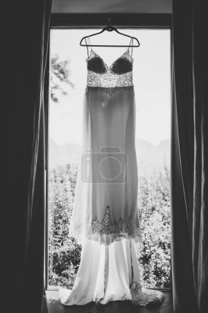 Photo for This captivating image showcases a wedding dress with intricate details photographed in creative and unique ways. The photograph features a stunning white wedding dress with intricate lace detailing and delicate beading. The dress is photographed fro - Royalty Free Image