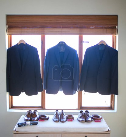 Photo for This captivating image showcases the groom's wedding attire, including his suit, shoes, and cufflinks, as he gets dressed for his big day. The photograph highlights the intricate details of the groom's ensemble, creating a beautiful composition that - Royalty Free Image