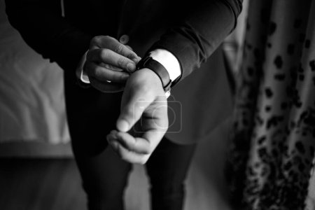 Photo for This captivating image showcases the groom's wedding attire, including his suit, shoes, and cufflinks, as he gets dressed for his big day. The photograph highlights the intricate details of the groom's ensemble, creating a beautiful composition that - Royalty Free Image
