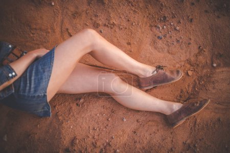 Foto de Imagen de cerca de una mujer bonita con piernas musculosas caminando por un camino de tierra usando zapatos de cuero hechos a mano. - Imagen libre de derechos