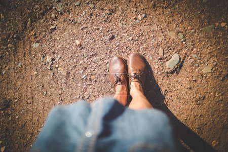 Photo for Close up image of a pretty woman with muscular legs walking on a dirt road wearing handmade leather shoes. - Royalty Free Image