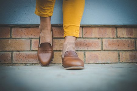 Photo for Close up image of a pretty woman with muscular legs wearing handmade leather shoes. - Royalty Free Image