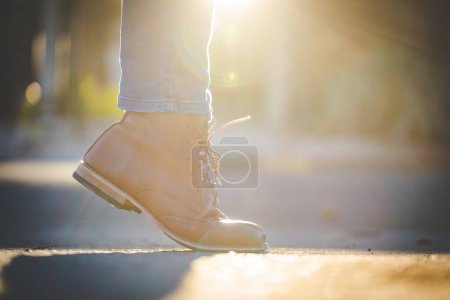 Photo for Close up image of a pretty woman with muscular legs wearing handmade leather boots. - Royalty Free Image