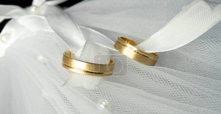 Photo for Gold Wedding rings white bow ribbon - Royalty Free Image
