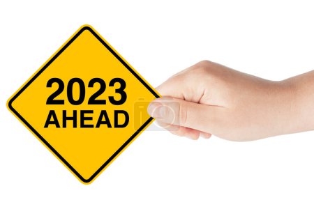 Téléchargez les photos : 2023 Année à venir Panneau de circulation dans la main de la femme sur un fond blanc - en image libre de droit