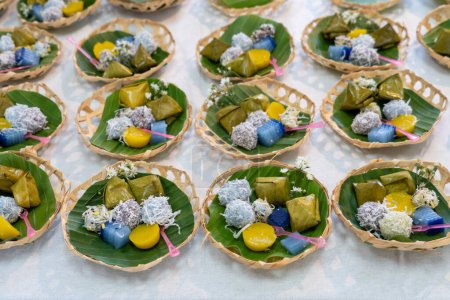 Süße thailändische Desserts auf traditionellem Teller, Kokosmilchquellen Blütenform mit Früchten im Inneren, süße thailändische Desserts