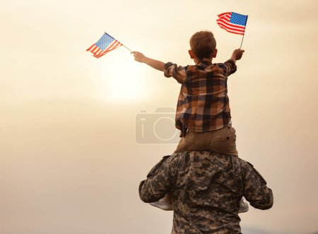 Téléchargez les photos : Vue arrière de l'homme militaire père portant heureux petit fils avec drapeau américain sur les épaules et bénéficiant d'une vue incroyable sur la nature d'été le jour ensoleillé, heureux soldat papa réuni avec son fils après l'armée américaine - en image libre de droit