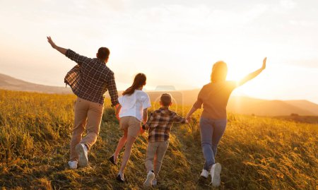 Téléchargez les photos : Famille heureuse : mère, père, enfants fils et fille courant sur la nature au coucher du soleil - en image libre de droit