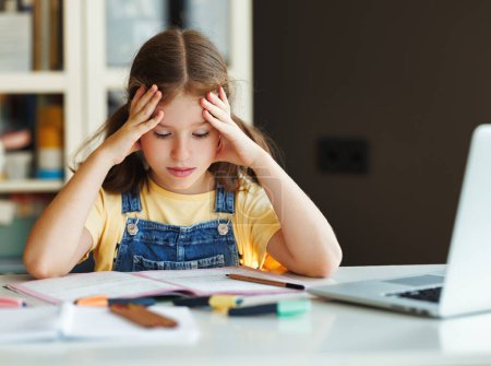 Téléchargez les photos : Fille frustrée penser à une tâche difficile et toucher la tête tout en faisant des devoirs à table - en image libre de droit
