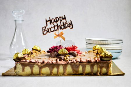 Foto de Birthday  cake decorated with chocolate pieces with happy birthday text - Imagen libre de derechos