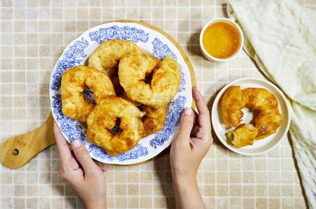 woman hand eating a traditional Algerian fried baked  donuts or pancake named Sfenj 