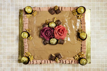 Foto de Birthday cake decorated with chocolate pieces and roses flowers - Imagen libre de derechos