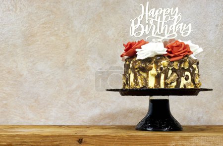 Foto de Pastel de capa de cumpleaños decorado con piezas de chocolate con texto feliz cumpleaños en soporte de pastel en tablero de madera - Imagen libre de derechos