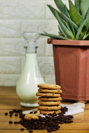 Photo for Coffee bean, homemade tasty cookies and milk bottle and aloe vera pot - Royalty Free Image