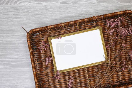 Photo for Golden picture or photo frame mockup with pink baby's breath, gypsophila on esparto halfah background - Royalty Free Image