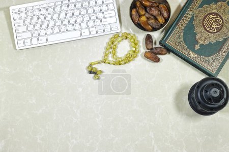 eid concept. lantern and muslim book with Arabic calligraphy Quran - translation : the noble book of Muslims around the world and dates fruit , rosary muslim and  keyboard