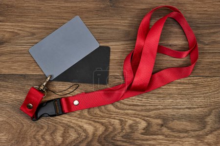 Grey card with a red strap on wood table, a photographers tool, determining the correct white balance