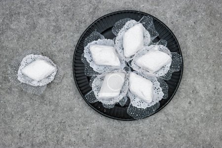 plate with algerian traditional cookies named makrout is a almond paste forming diamond shape and covered with icing sugar