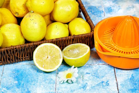 Halfah-Korb voller Zitronen auf Holztisch mit Kunststoffpresse, Gartenkonzept, Limonadenwerbung