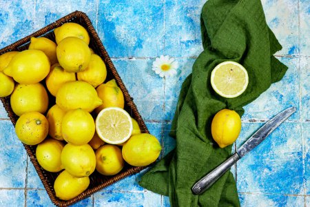  halfah cesta llena de limones sobre fondo de baldosas de madera, concepto de jardinería, publicidad limonada