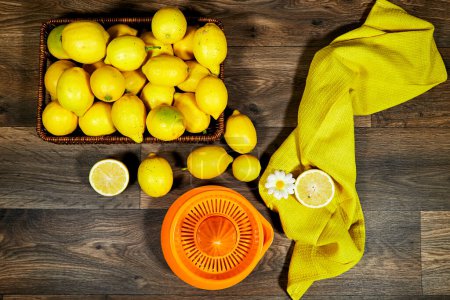 Halfah-Korb voller Zitronen auf Holztisch mit Kunststoffpresse, Gartenkonzept, Limonade