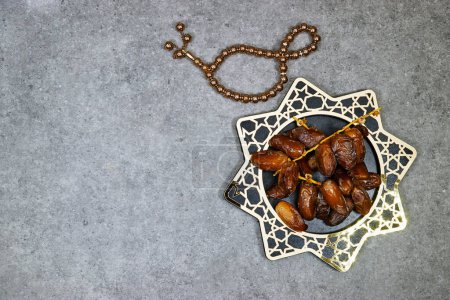happy ramadan or eid concept, deglet nour algeria dates in stars plate with rosary tasbih