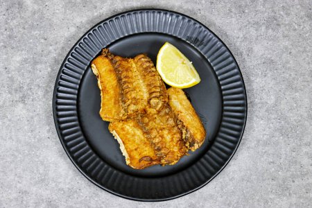 grilled Ray or skate filet decorated with slice of lemon 
