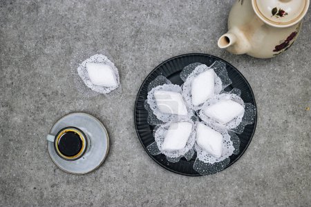 Teller mit algerischen traditionellen Keksen namens Makrout ist eine Mandelpaste, die Diamantform bildet und mit Puderzucker mit einer Tasse Kaffee bedeckt ist
