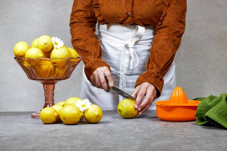 lifestyle photo of woman cutting  a fresh yellow lemon for preparing a citrus juice