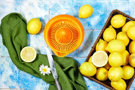 Photo for Halfah basket full of lemons on wood table with plastic squeeze, Gardening concept, lemonade - Royalty Free Image