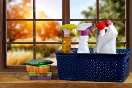 sponges and natural cleaning products in the basket near window showing olives field. Eco-friendly cleaning products